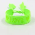 Detail van neongroene geweven armband met geel LOVE-borduurwerk en kwastjes eraan - Neon Groen LOVE Stijl
