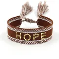 Bruine geweven vriendschapsarmband met gouden HOPE-studs en kwastjes op witte achtergrond - Gouden HOPE Stijl