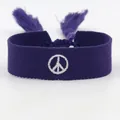 Dettaglio del braccialetto dell'amicizia intrecciato viola con segno di pace e nappe - Segno della Pace Viola