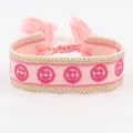 Adjustable pink embroidered woven bracelet with smiling faces and tassel fringe detail - Smiley Embroidery / Pink