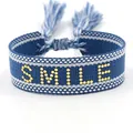 Blue and white woven bracelet featuring a gold SMILE emblem and stylish tassel accents - Gold SMILE Style 2