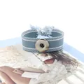 Vista macro de la pulsera tejida azul con botón a presión ajustable y detalle de borla - Azul (26#)