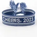 Blue and white woven friendship bracelet with CHEERS 2023 embroidery and tassels - 2023-4