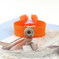 Vista macro de pulsera boho tejida en naranja brillante con botón a presión y borlas - Orange (6#)