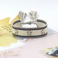 Primer plano de pulsera tejida de la amistad con remaches de estrella y borlas - Patrón Negro Crema (35#)