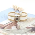 Primer plano de pulsera étnica con botón de presión correa de algodón y borlas blancas - Beige (11#)
