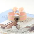 Primer plano detallado de la pulsera tejida rosa y amarilla con botón y borlas suaves - Rosa Amarillo (13#)