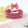 Primer plano del brazalete trenzado rosa con tachuelas de estrella plateadas y borlas - Lona Rosa (30#)
