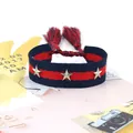 Pulsera trenzada con estrellas y borlas en azul marino y rojo sobre fondo de revista - Azul Marino Rojo (46#)