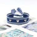Détail du bracelet tissé bleu avec clous en forme de cœur argentés et nœuds à franges - Dark Blue With White Dots
