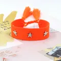 Detalle de pulsera tejida naranja con tachuelas de estrella plateadas y borlas suaves - Rojo Anaranjado (26#)