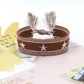 Detalle de una pulsera de la amistad tejida en marrón con estrellas y borlas - Marrón con Puntos (21#)