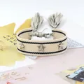 Pulsera tejida beige con tachuelas de estrellas plateadas y borlas en un escritorio - Blanco Roto Negro (36#)