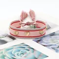 Pink woven friendship bracelet with golden heart rivets and colorful tassels - Gold Heart Rivets / Pale Pink (H-G-002)