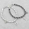 Magnetic couples bracelet set with black and white braided ropes and heart lock charm - Key Lock Pair