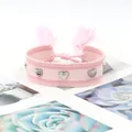 Bracelet tissé rose avec clous en forme de cœur argentés et pompons à franges - Pink Tones