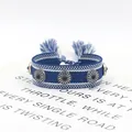 Pulsera trenzada azul con tachuelas de plata y borlas sobre fondo blanco limpio - Azul Y Blanco (12#)
