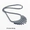 Detail van hematiet kralenketting met waaiervormige hanger en maatinformatie - Pianotoets Stijl