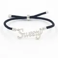 Detail van zwarte geweven armband met zilveren Sweety-uitsparing en verstelbaar koord - SWEETY Letter Stijl / Staal + Zwart