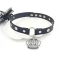 Punk style black leather choker with silver crown pendant and metal eyelets on white tray - Crown / Black