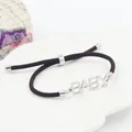 Verstelbare donkerbruine gevlochten armband met een zilveren metalen BABY letterplaat - BABY Letter Stijl / Staal Kleur + Bruin