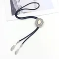 Detail of western bolo tie featuring white stone inlay and silver feather pendants - White Howlite