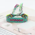 Close-up of handmade woven friendship bracelet with colorful geometric patterns and tassels - Cyan Red Yellow Gray Geometric Style (A#(5))