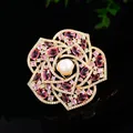 Luxurious camellia flower brooch with pink zircons and center pearl on black background - Magenta Camellia