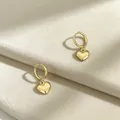 Nahaufnahme goldener Herz-Creolen auf einem weißen Samt-Displayständer - Gold