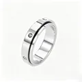 Polished silver spinner ring with a sleek black line and inset cubic zirconia stones - US 5 / Zirconia Inlaid / Silver