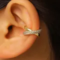 Close-up of an X-shaped gold-tone ear cuff with pavé white zircons. - Gold (Gold 3459)