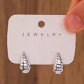 Silver-tone spiral textured C-shape stud earrings displayed on a jewelry card - Silver Spiral Conch Stud Earrings / Silver (N-195)