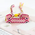 Detail of colorful bohemian handmade woven friendship bracelet with tassels on pink desk - Pink Red White Purple Yellow Geometric Style (A#(15))