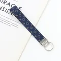 Dettaglio del portachiavi ricamato blu con motivi geometrici e chiusura in argento - Geometrico con Motivo H Rosso Blu (09-03D)