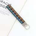 Dettaglio portachiavi da polso intrecciato etnico con motivi geometrici colorati - Rombo Arancione Blu Marrone (09-03F)