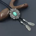 Detail van vintage bolo-das met turquoise steen en metalen veren hangers - Groen