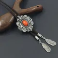 Detail van vintage bolo tie met rode edelsteen en zilveren veerhangers in detail - Oranje