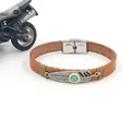 Detailed macro of vintage brown leather bracelet with turquoise feather metal charm - Vintage Light Brown
