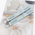 Detailed macro view of the Cheers 2025 embroidered blue webbing keychain with silver hardware - Blue Jacquard Ribbon Style / Blue CHEERS 2025