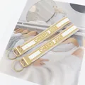 Set of two white embroidered Cheers 2025 ribbon keychains with gold metal rings - White with Gold Edge Embroidery Style / Cream Gold CHEERS 2025