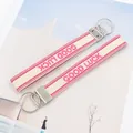 Detail von zwei gewebten Schlüsselbändern mit rosa Good Luck Stickerei und Silberringen - Good Luck Stil 4