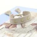 Detail van bohemien geweven armband met gouden maanborduurwerk en kwastjes koord - Maan Stijl / Grijs