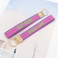 Set aus rosa-lila GOOD LUCK Stickerei-Schlüsselanhängern mit goldenem Metallverschluss - Good Luck Stil 1