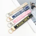 Llaveros bordados con eslogan GOOD VIBES en cuatro colores variados con cierre - Personalizado Contáctenos