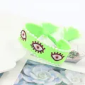 Detail of neon green woven bracelet with embroidered evil eyes and pearl beads trim - Fluorescent Green