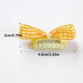 Détail d'un nœud papillon à carreaux jaunes pour animaux avec perles et dimensions - Pince BB Nœud Perle à Carreaux Orange et Blanc - Fond Jaune