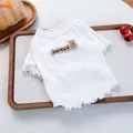 Nahaufnahme von weißem geripptem Haustierpullover mit Bären-Patch und Rüschensaum - Weiß