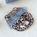 Dettaglio della mutandina igienica per cani maculata con pizzo blu e foro per la coda - Stile Stampa Leopardata