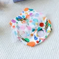Dettaglio dei pantaloni igienici per cani a pois colorati con pizzo e foro per coda - Stile a Grandi Pois Colorati