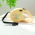 Detail of yellow retractable dog leash featuring cartoon graphics and ergonomic handle grip - Together Cartoon Puppies Style / Bright Yellow